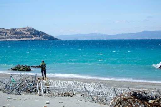 A serviceman from Morocco’s Auxiliary Forces patrols Belyounech beach. On the horizon lies Spain. The route in between is known as the Western Mediterranean route. In 2018, it was the most frequented route by irregular migrants to reach Europe. © Saâdia Dinia 2017.