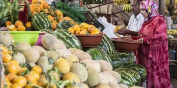 Couple buying Oranges at Agadir's Souk Market. FAO