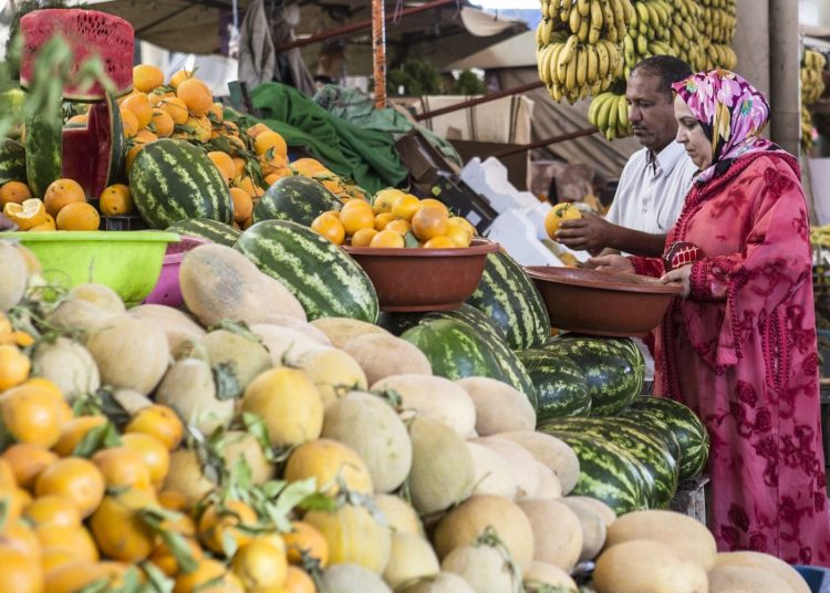 Couple buying Oranges at Agadir's Souk Market. FAO