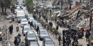 Cars drive past rubble from damaged buildings in Beirut’s southern suburbs