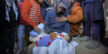 Yahya al-Batran holding the body of his 20-day-old son Jumaa