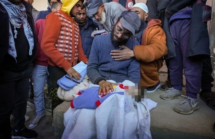 Yahya al-Batran holding the body of his 20-day-old son Jumaa