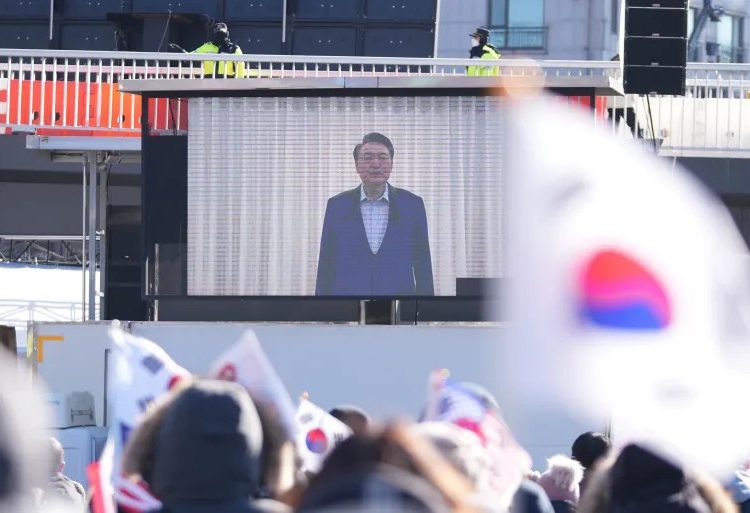 A screen shows footage of impeached Yoon Suk-yeol as supporters stage a rally to oppose his impeachment near the presidential residence in Seoul credits: Lee Jin-man/AP Photo.