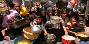 Palestinians struggle to get donated food at a community kitchen in Jabalia, northern Gaza Strip [File: Jehad Alshrafi/AP]