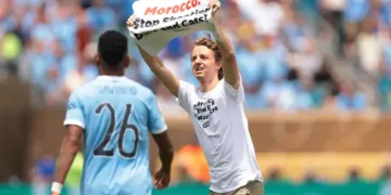 A young man ran onto the field during the Club World Cup match between Wydad Casablanca and Manchester City on Wednesday, holding a sign that read, “Morocco: Stop shooting dogs and cats.”