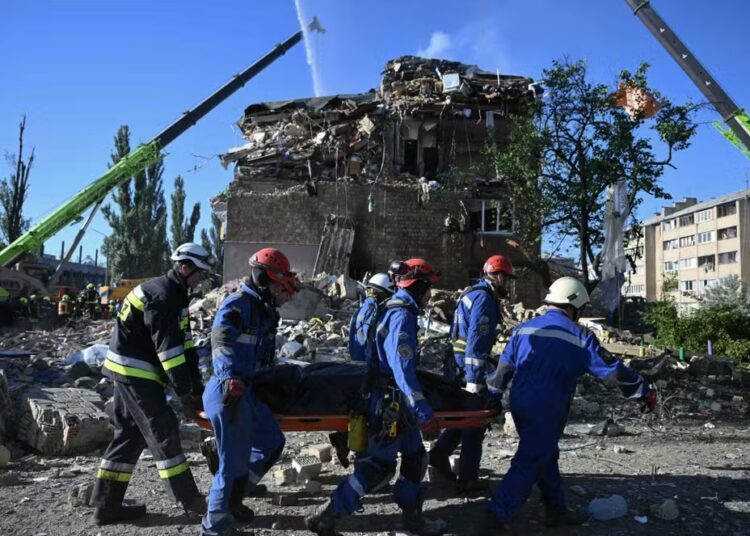 Rescuers carry the body of a victim after Russian strikes in Kyiv, on August 28, 2025. (GENYA SAVILOV / AFP)