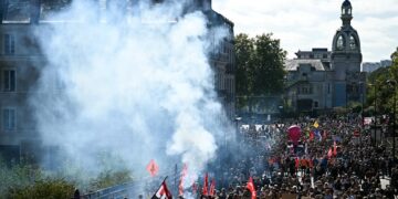 Protesters hold placards and wave flags as they take part in a demonstration in the streets of Nantes, western France. © Loic Venance, AFP