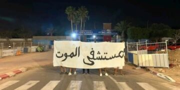 Protestors holding a sign that reads "Death Hospital" in front of the regional Hassan II Hospital in Agadir