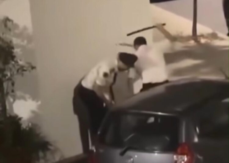 Image from a viral video showing two police officers violently beating a young man