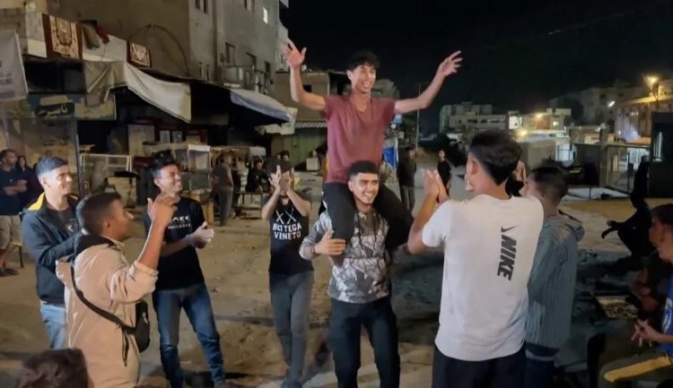 Palestinians celebrate on a street in Khan Younis in the southern Gaza Strip on October 9, 2025 [Reuters]
