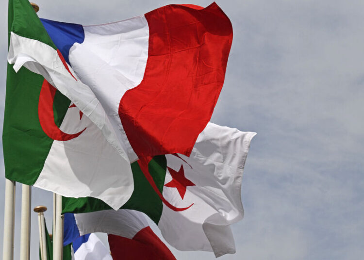 The Algerian and French flags sway in the wind in the Algerian capital on October 9, 2022, upon the arrival of the French PM to Algiers on a two day official visit. (Photo by Alain JOCARD / AFP)