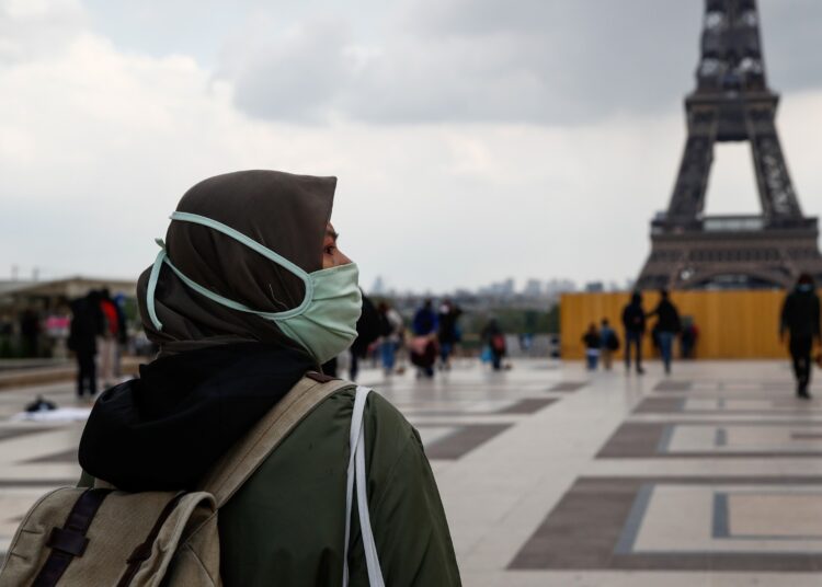 A woman, wearing a hijab and a protective face mask, walks at Trocadero square near the Eiffel Tower in Paris, France, May 2, 2021. Picture taken on May 2, 2021. REUTERS/Gonzalo Fuentes