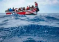 A group of migrants travels by boat across the sea.