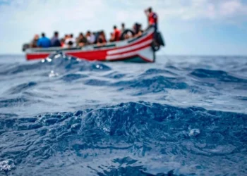 A group of migrants travels by boat across the sea.