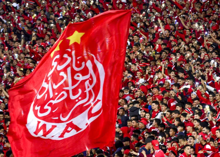 Supporters hold a giant Wydad's flag as they attend the CAF Champions league's match between Wydad Casablanca and Zamalek at the Mohammed V Stadium, in Casablanca, on February 26, 2022, after the reopening of the football fields in Morocco. (Photo by AFP)