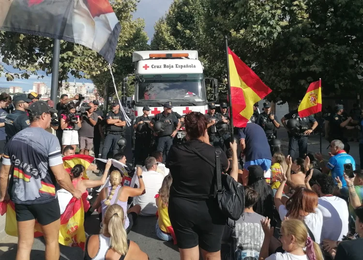Residents waving Spanish flags marched through the enclave, chanting for the migrants to leave and trying to block Red Cross vehicles from delivering food.