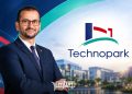 A graphic featuring Driss Lemjaouri alongside the Technopark logo and a modern business park setting, by MWN Design Team.