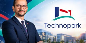 A graphic featuring Driss Lemjaouri alongside the Technopark logo and a modern business park setting, by MWN Design Team.
