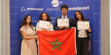 Moroccan students display their AeroSTAR achievement certificates alongside Morocco’s flag at a ceremony organized by Boeing and Amideast.