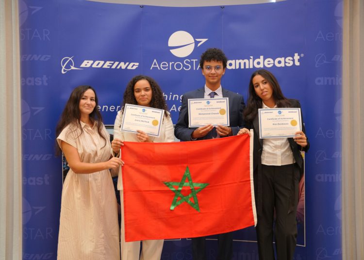 Moroccan students display their AeroSTAR achievement certificates alongside Morocco’s flag at a ceremony organized by Boeing and Amideast.
