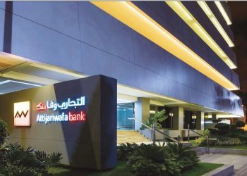 Attijariwafa Bank’s headquarters in Morocco, illuminated at night, with the bank’s logo prominently displayed on the building’s exterior.