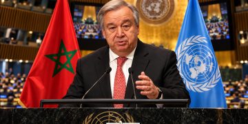UN Secretary-General António Guterres pictured at the UN General Assembly podium alongside the Moroccan and United Nations flags. (Designed by MWN team)