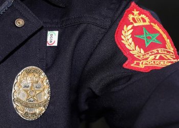 A close-up of a Moroccan police uniform displaying the official badge and insignia of the General Directorate of National Security (DGSN).